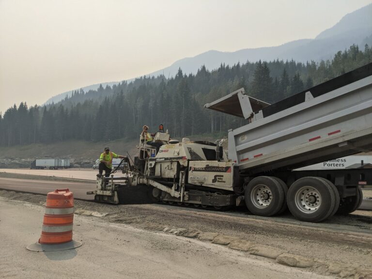 people working on a heavy machinery in the road